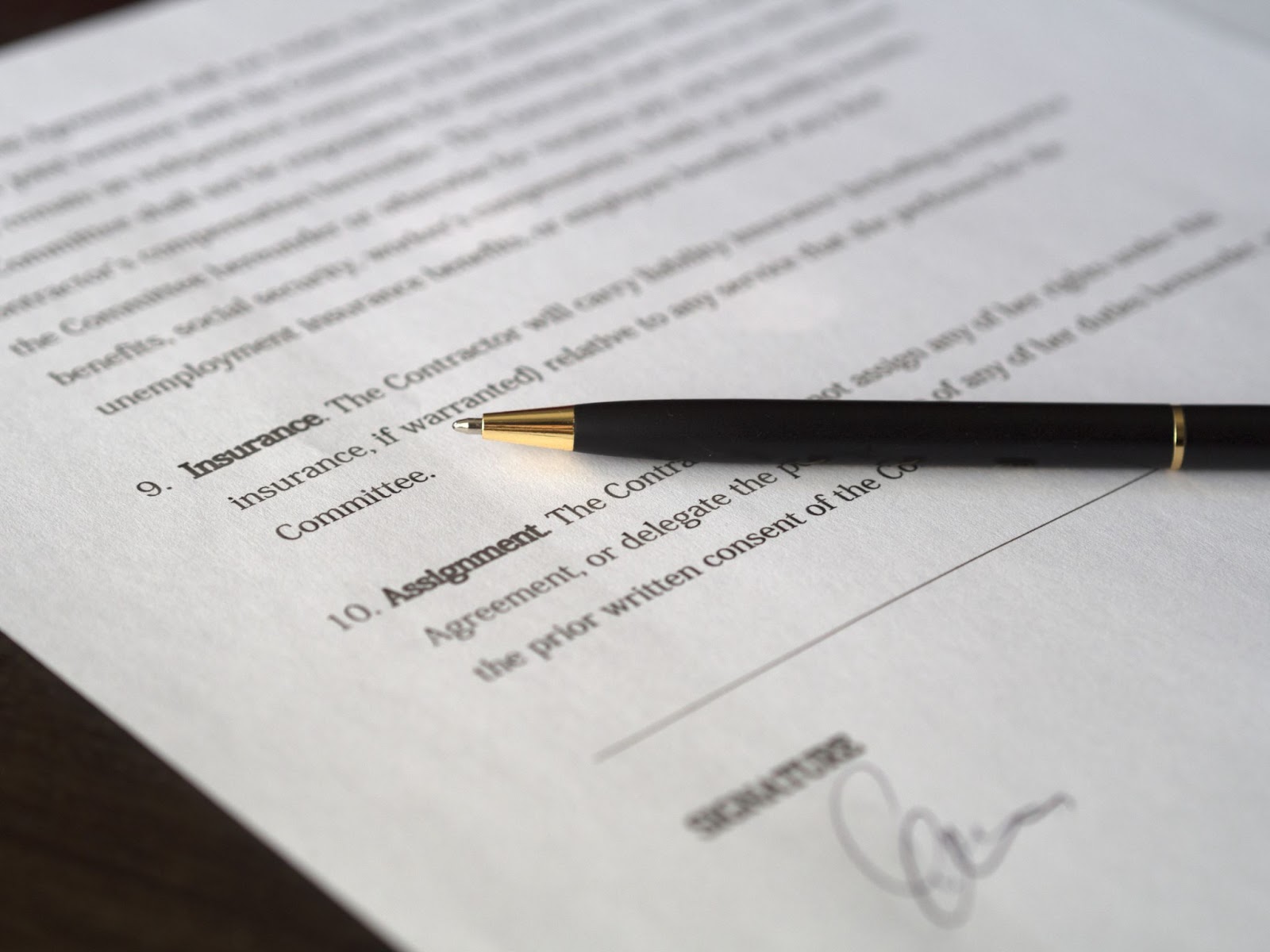 Black pen placed on a document signed up for a new refinance.