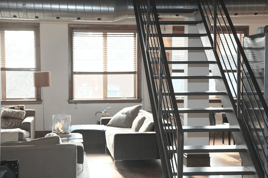 cozy two-storey apartment with large windows and a small portable fireplace