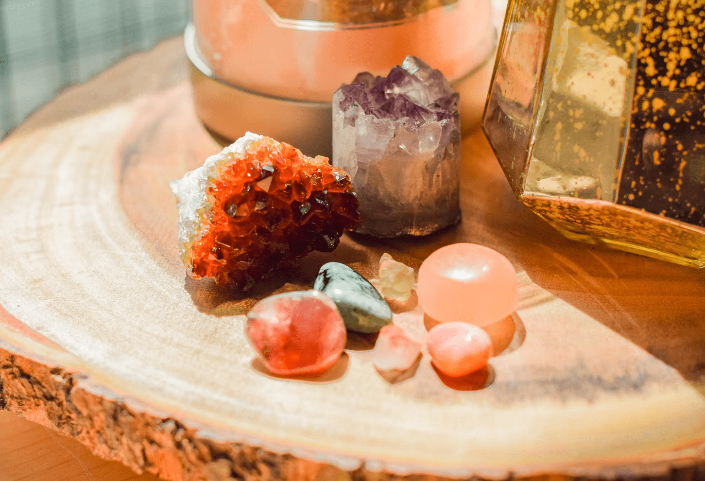 small different stones on a wooden round board next to the candles