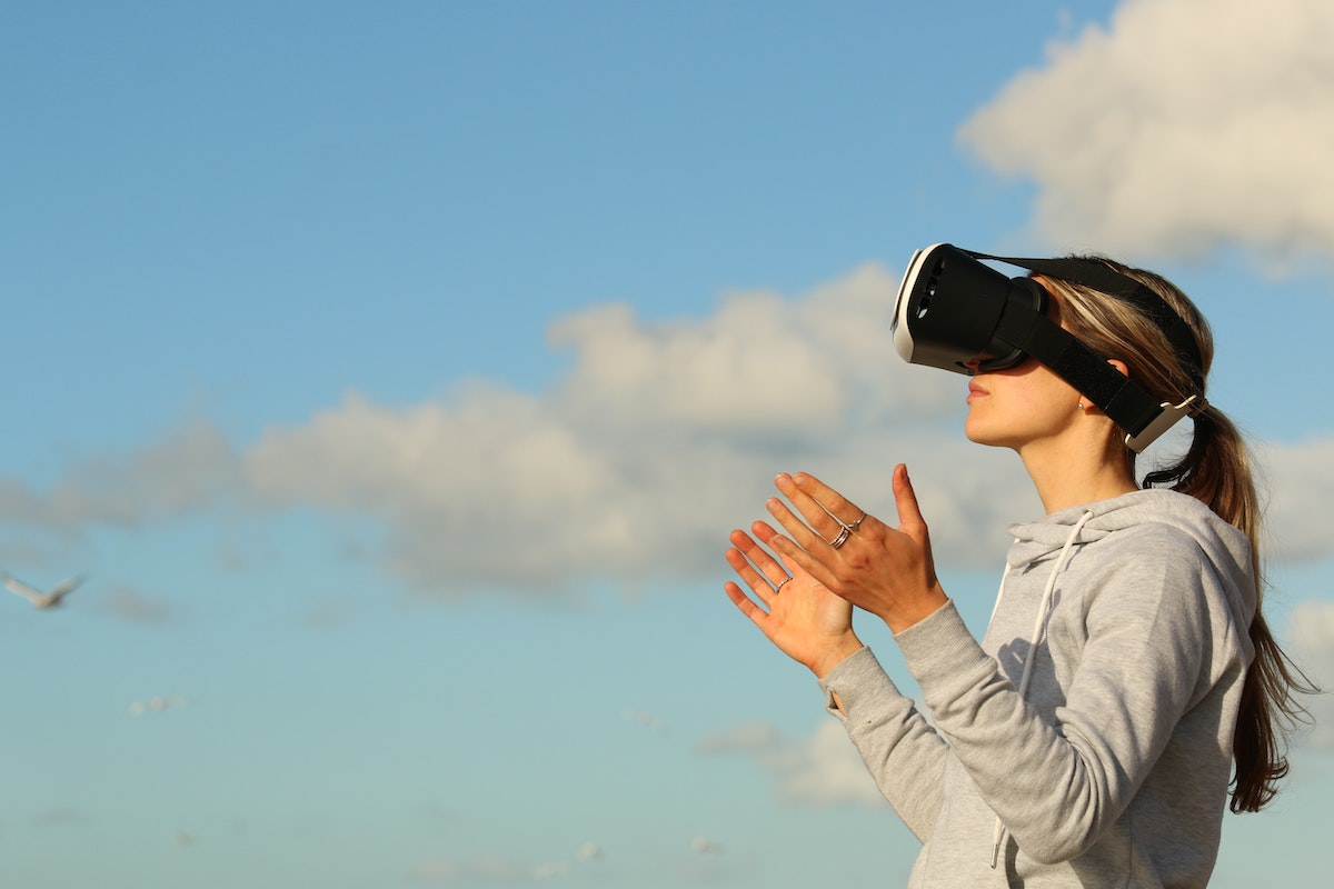 A woman using VR goggles outdoors for a virtual home tour