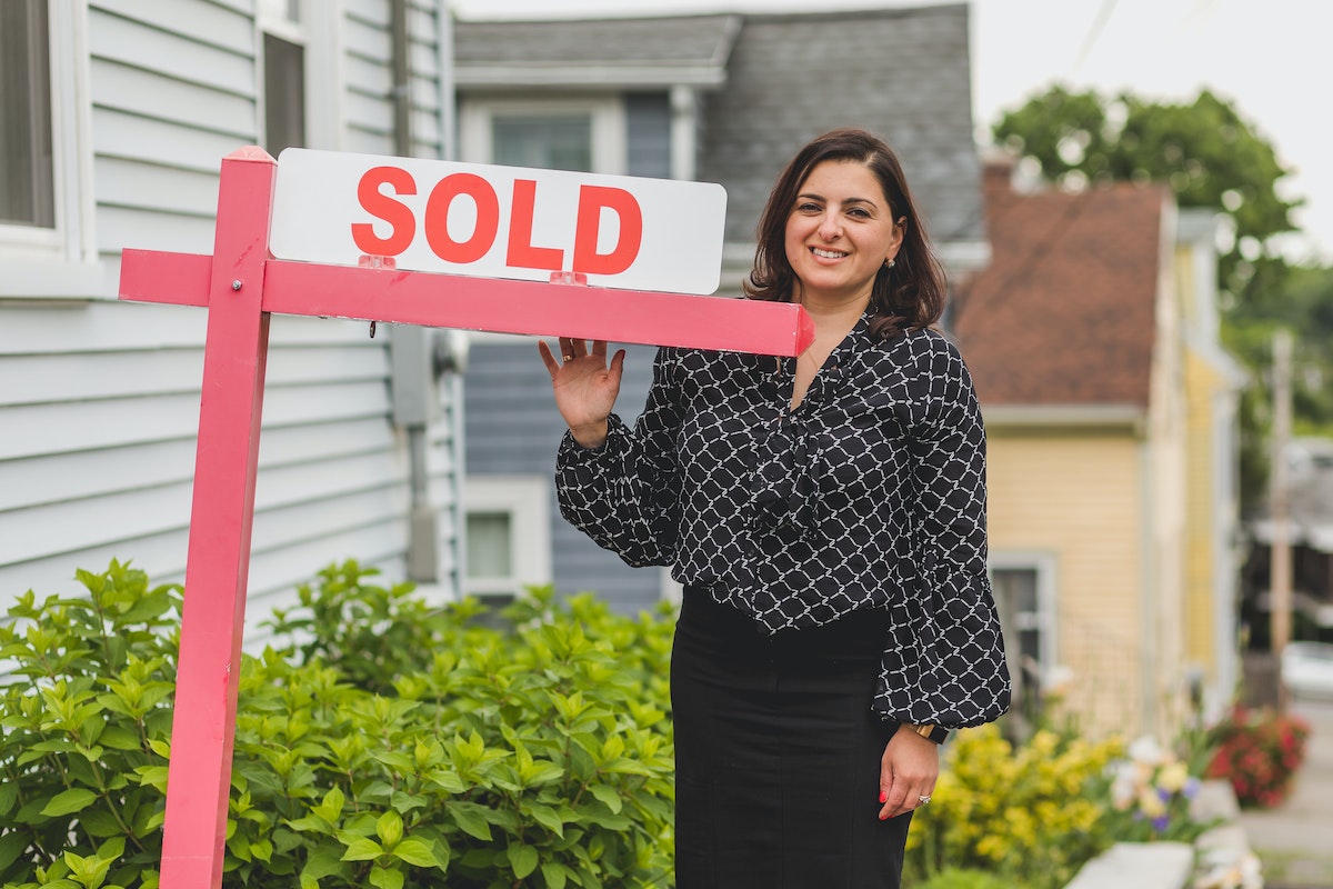 Realtor in Boston with a SOLD sign.